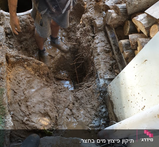 אדם עובד בבור בוץ עם צינור פלסטיק